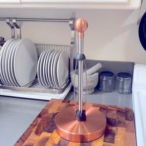 Copper/rose gold rotating paper towel holder.